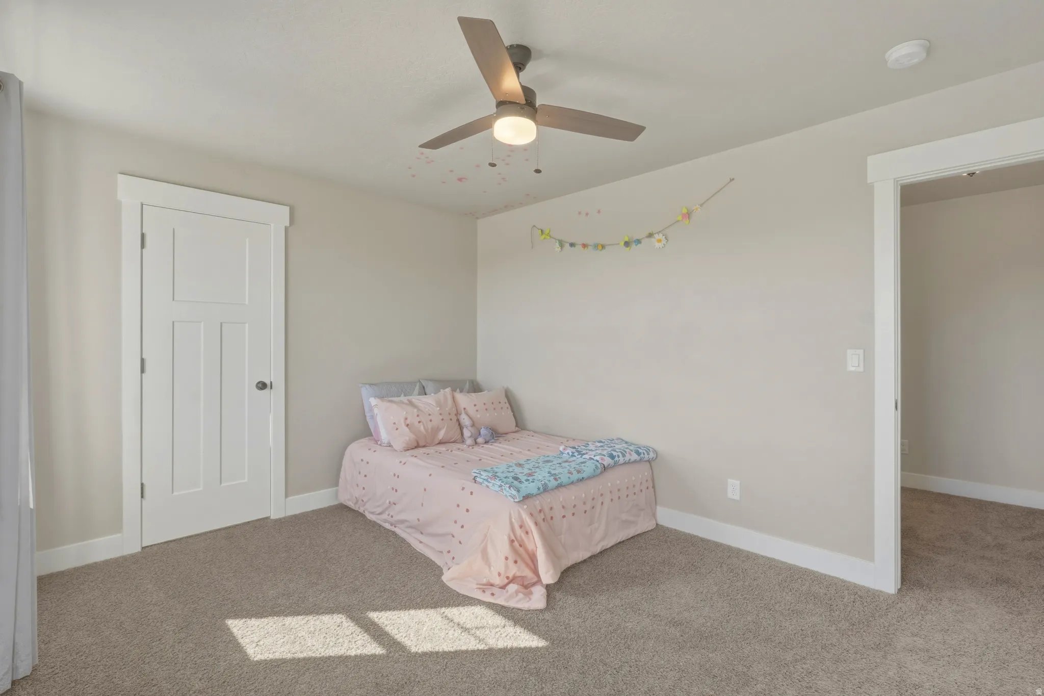 Carpeted bedroom with baseboards and ceiling fan