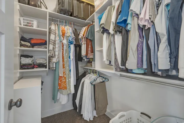 Walk in closet featuring dark carpet