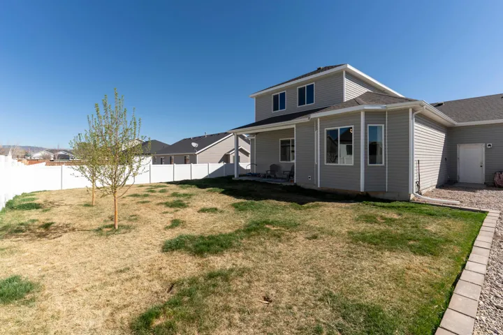 Rear view of house with a patio area, a fenced backyard, and roof with shingles