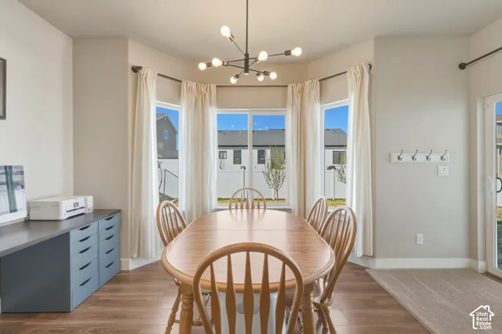 Dining space featuring suspended lighting and wood finished floors