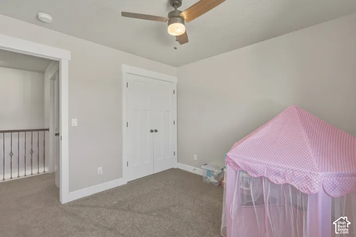 Bedroom with carpet floors, a closet, a ceiling fan, and a textured ceiling
