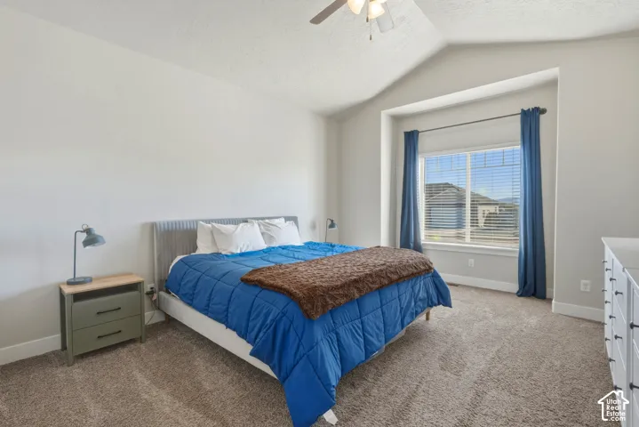 Bedroom with light colored carpet, a ceiling fan, and a textured ceiling