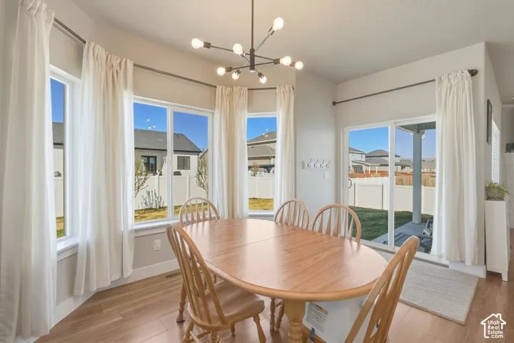 Dining area with hanging lights and light wood-style floors