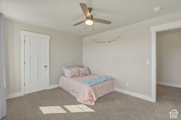 Carpeted bedroom with baseboards and ceiling fan
