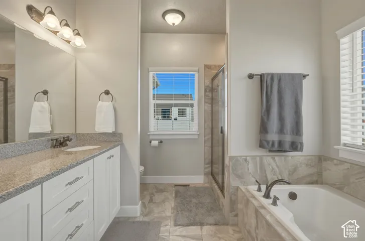 Full bath featuring vanity, a shower stall, and a garden tub