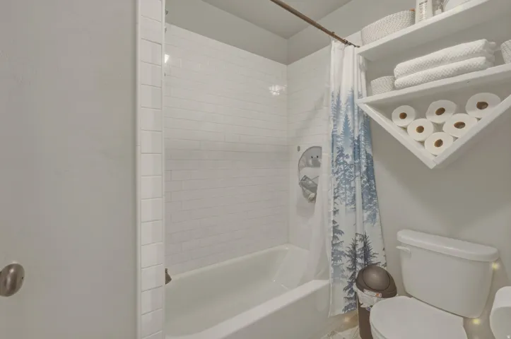 Bathroom with toilet and shower / bath combo with shower curtain