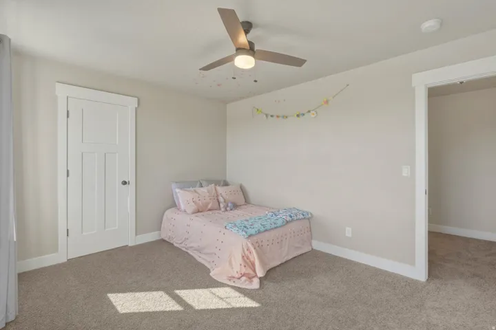 Carpeted bedroom with baseboards and ceiling fan