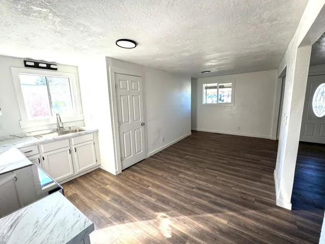 Unfurnished dining area with dark wood-style flooring and a textured ceiling