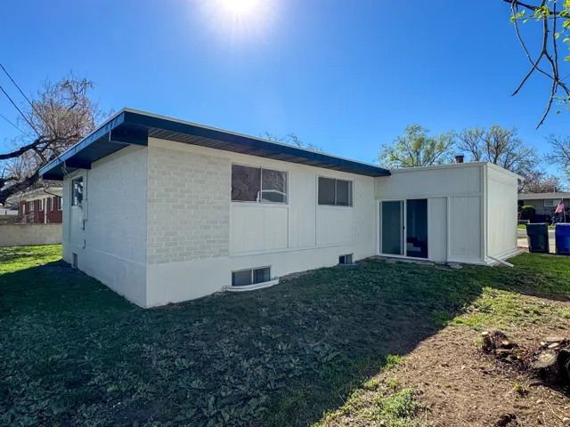 Rear view of property featuring a yard and brick siding