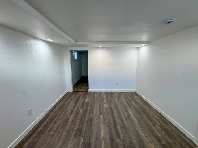 Unfurnished room with dark wood-style flooring, a smoke detector, and recessed lighting