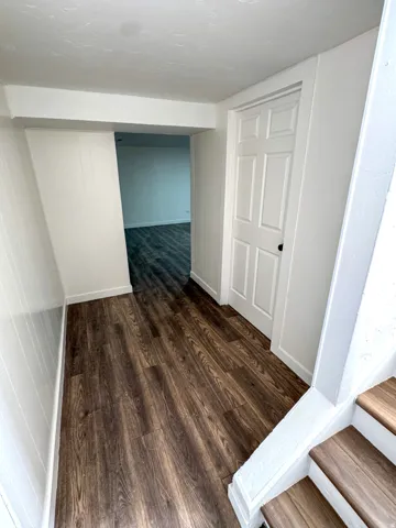 Corridor featuring dark wood finished floors and baseboards