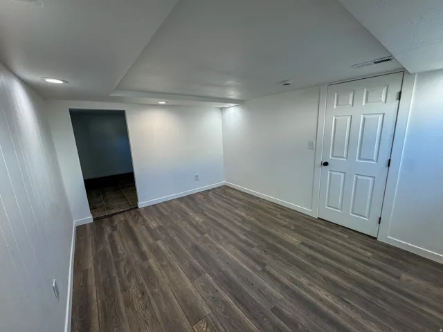 Finished basement featuring dark wood finished floors and recessed lighting