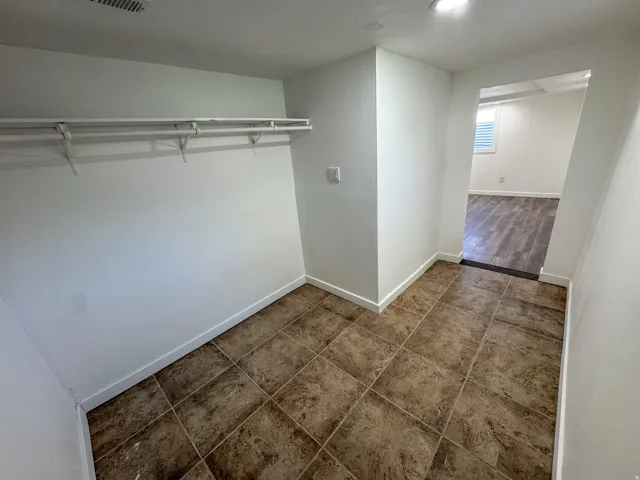 Walk in closet with dark tile patterned floors