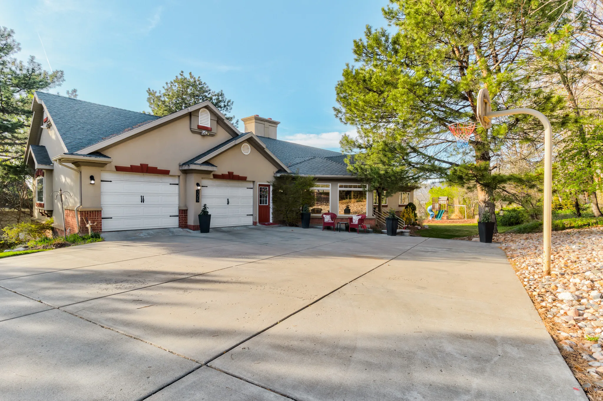 Traditional-style house featuring brick siding, a shingled roof, concrete driveway, and stucco siding
