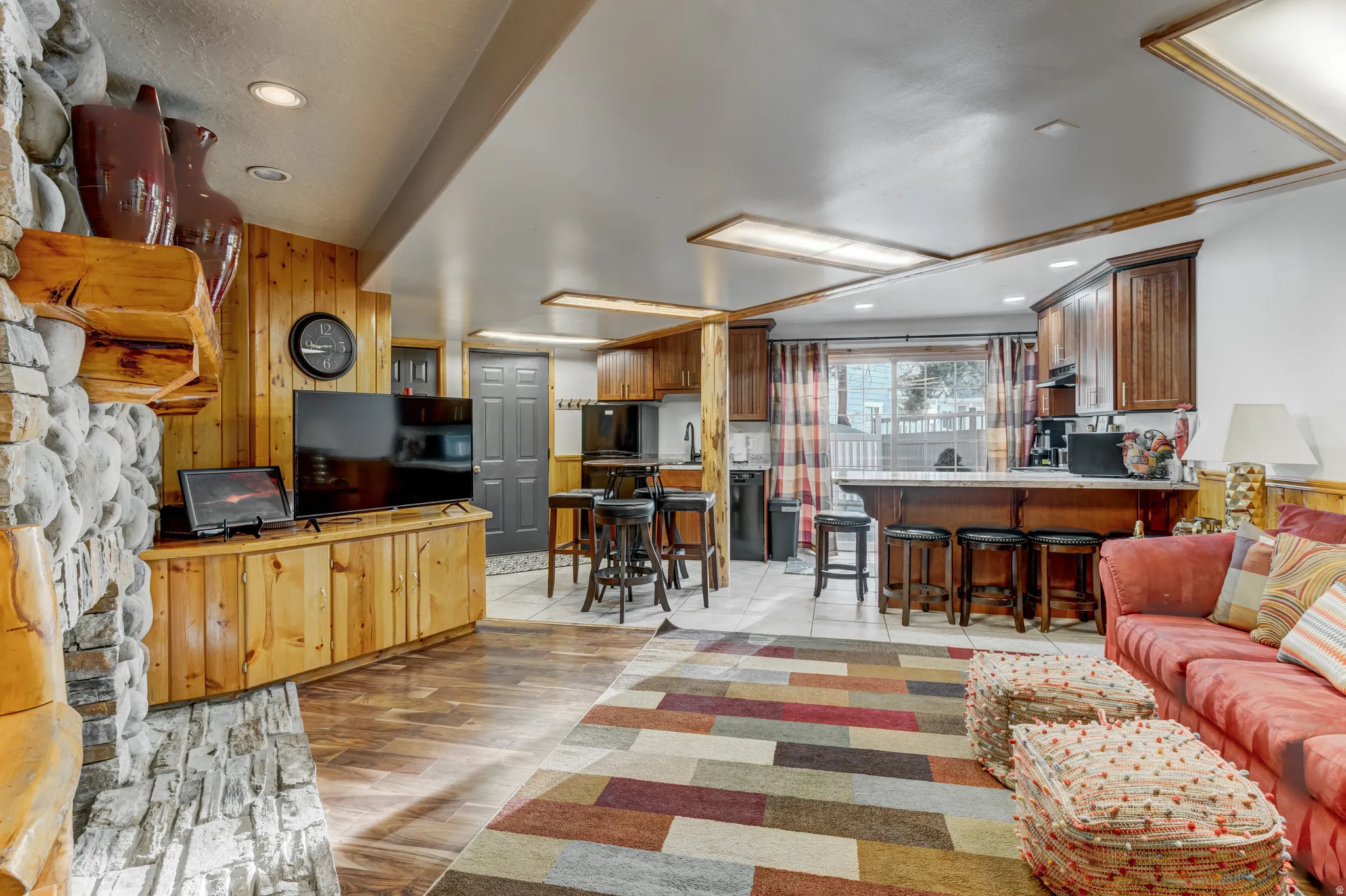 Living area with light wood-style flooring, wood walls, and recessed lighting