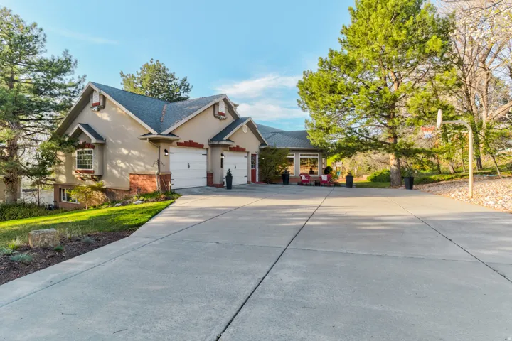 Traditional home with driveway, brick siding, an attached garage, and roof with shingles