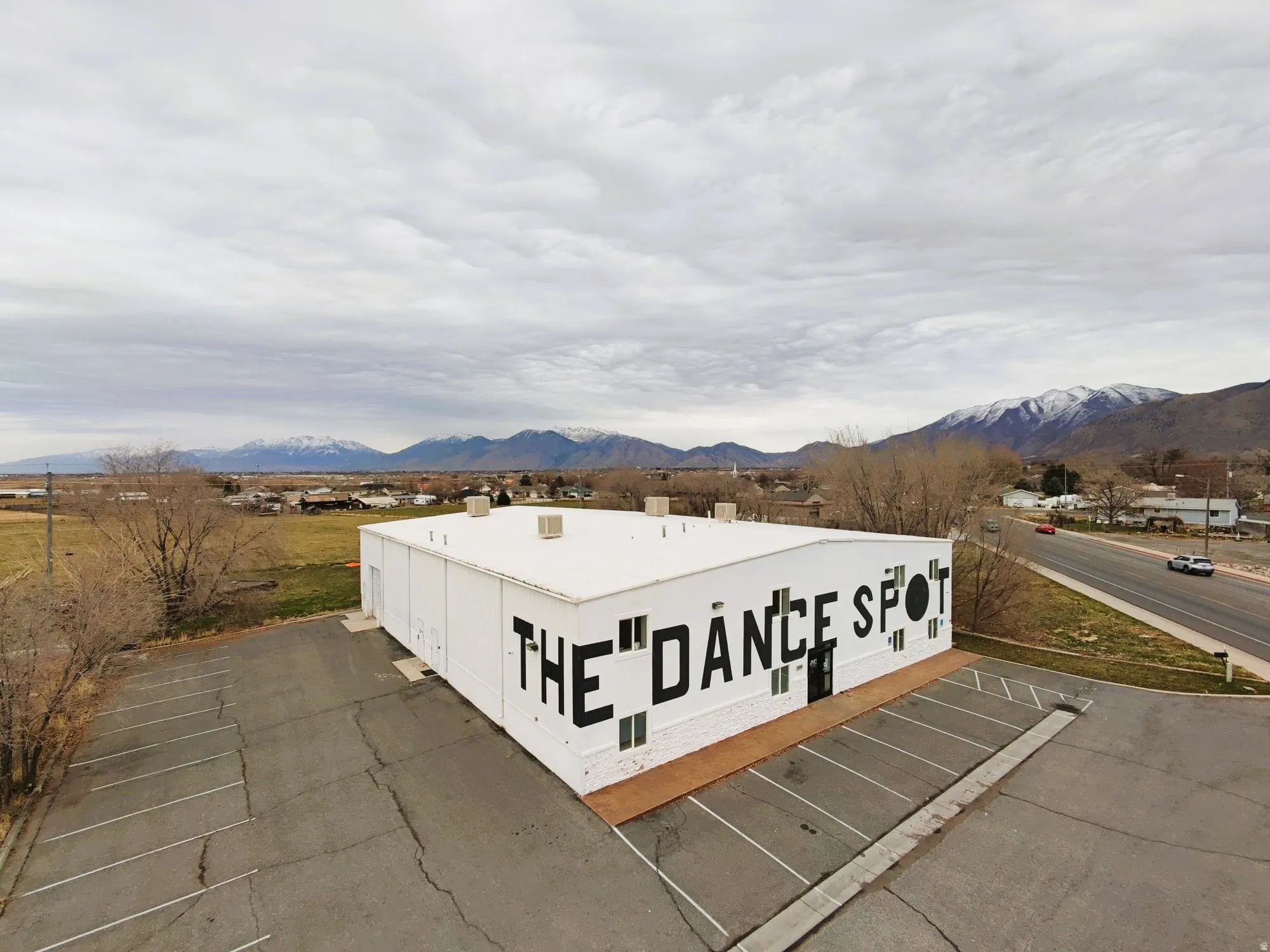 View of building exterior with a mountain view and uncovered parking