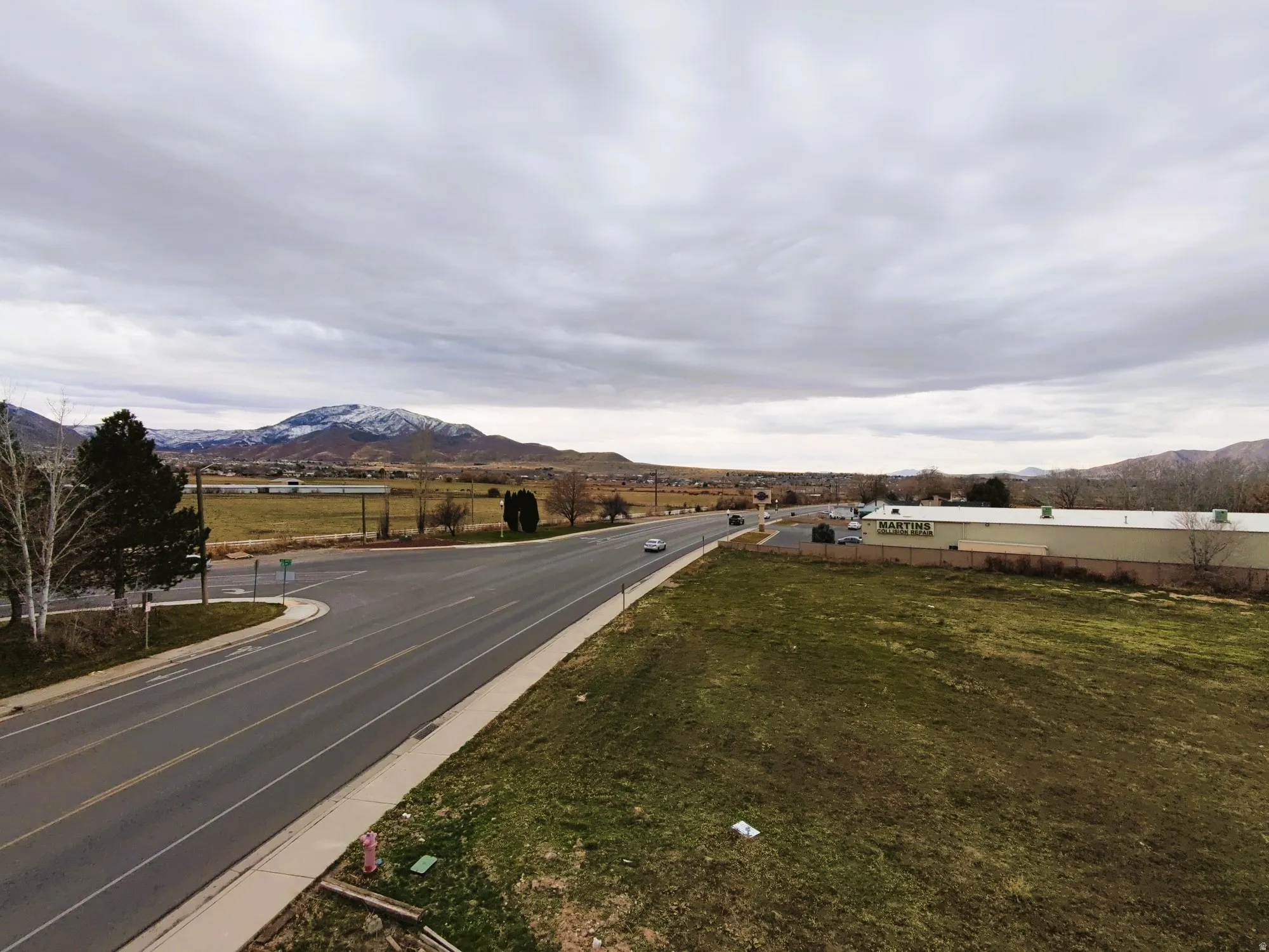 View of asphalt street featuring a mountain view and curbs