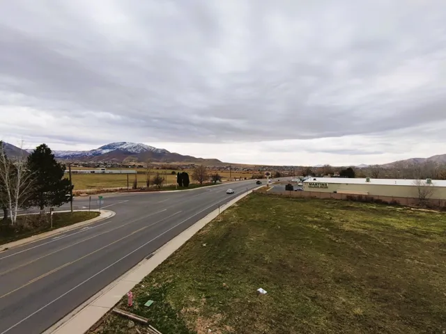 View of asphalt street featuring a mountain view and curbs