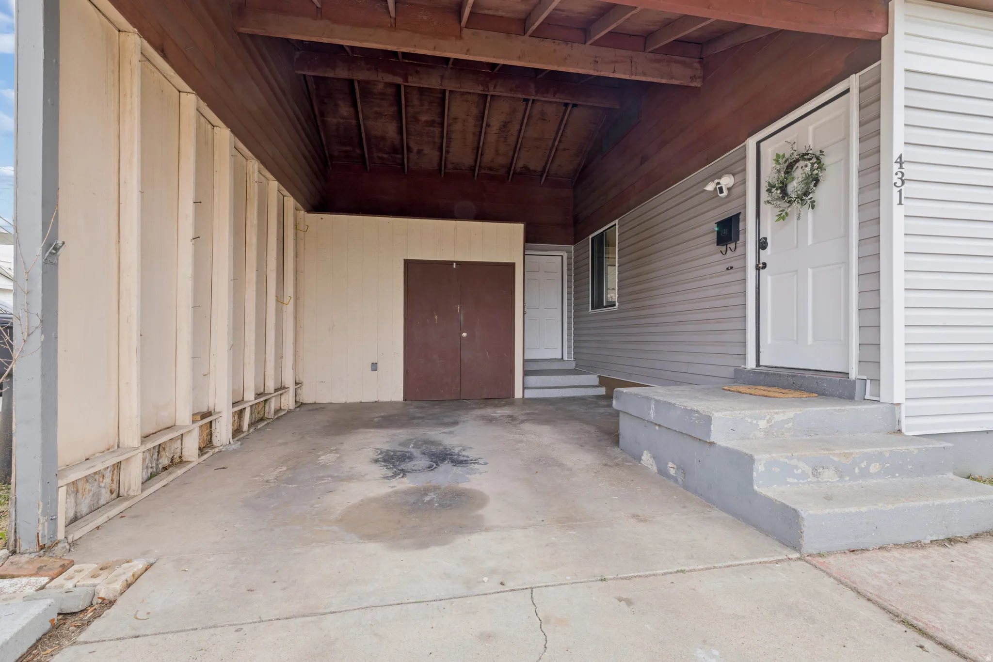 Property entrance with a patio and an attached carport