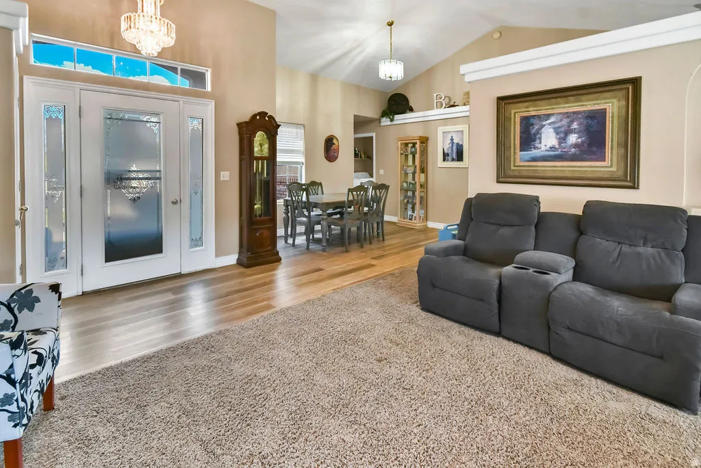 Living area with hanging lights, a high ceiling, and light carpet