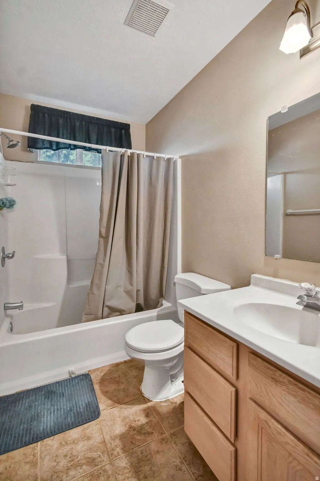 Bathroom with vanity and shower / tub combo with curtain