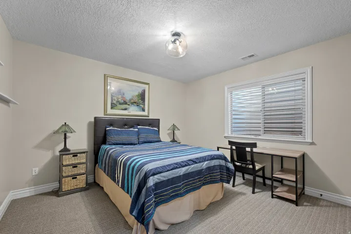 Bedroom featuring light carpet and a textured ceiling
