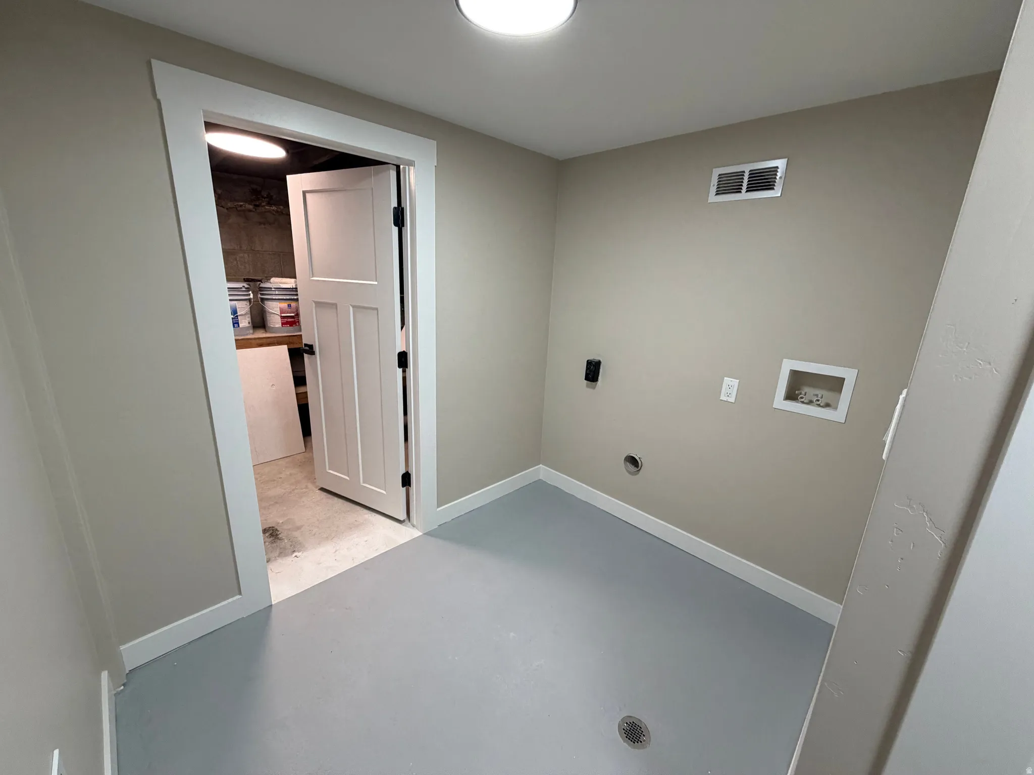 Laundry room with finished concrete floors, washer hookup, and electric dryer hookup