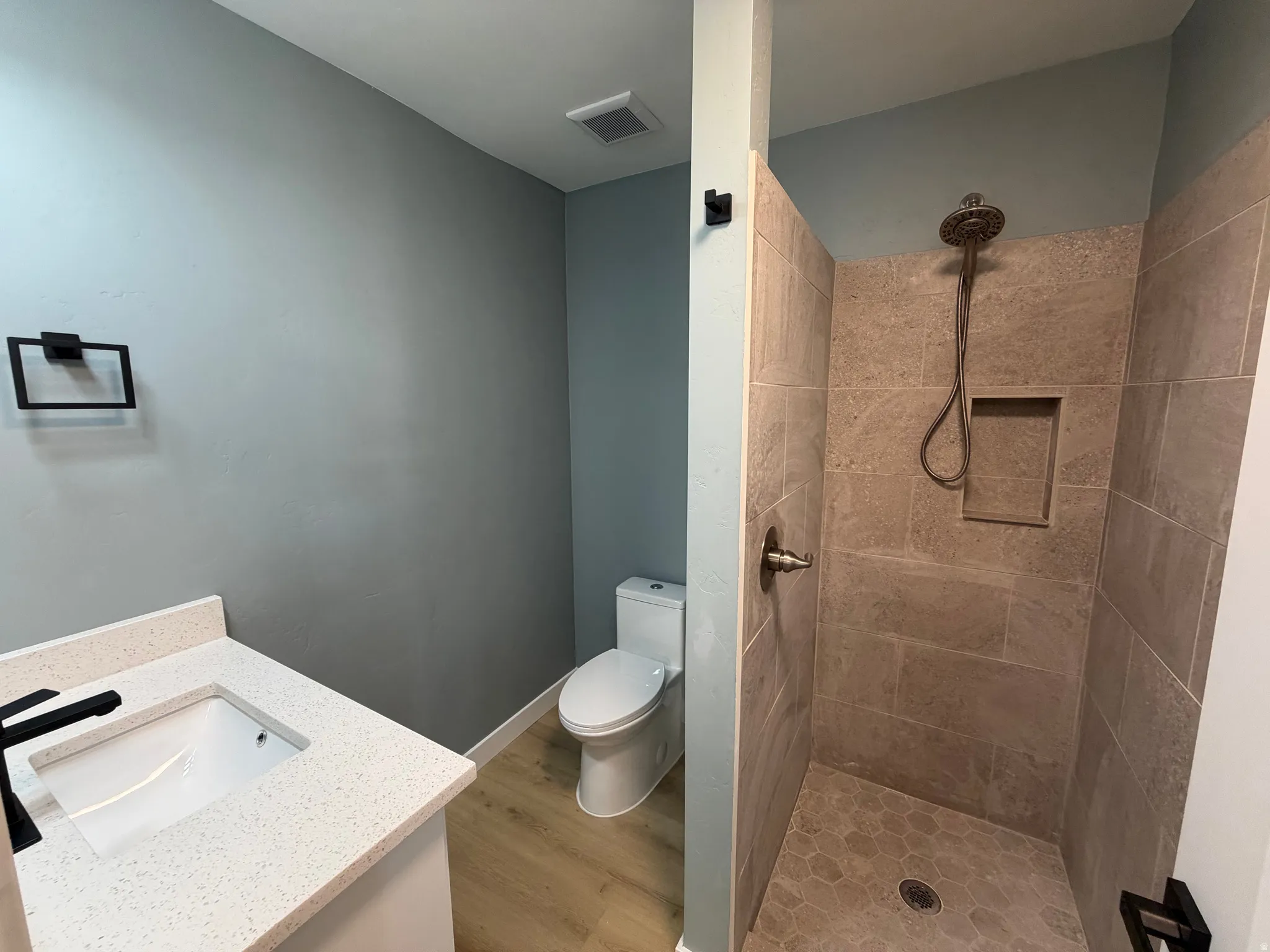 Bathroom featuring vanity, a stall shower, and light wood-style floors