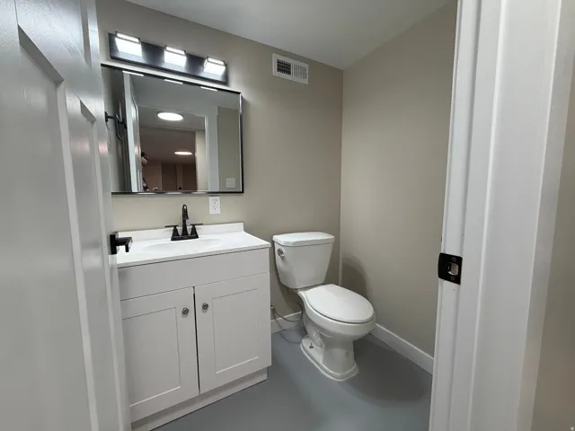 Half bath with vanity and finished concrete flooring
