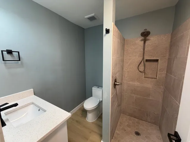 Bathroom featuring vanity, a stall shower, and light wood-style floors