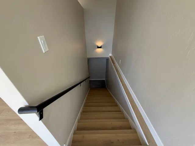Staircase with wood finished floors and baseboards