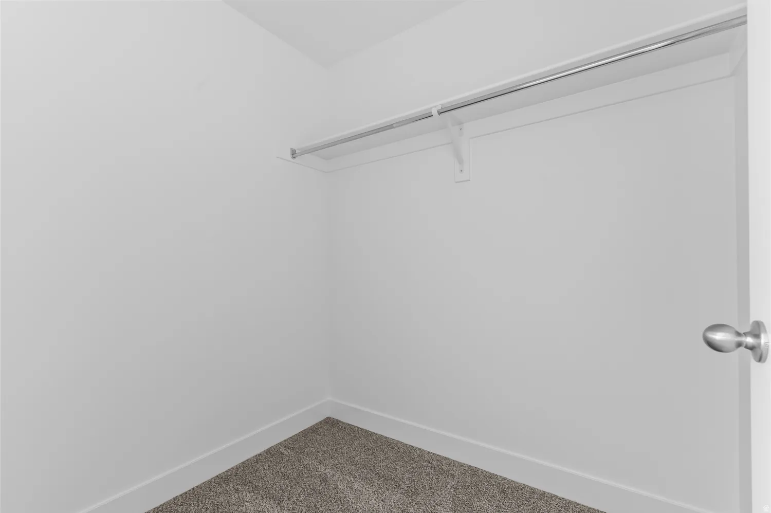 White interior walls with a built-in closet rod and shelving