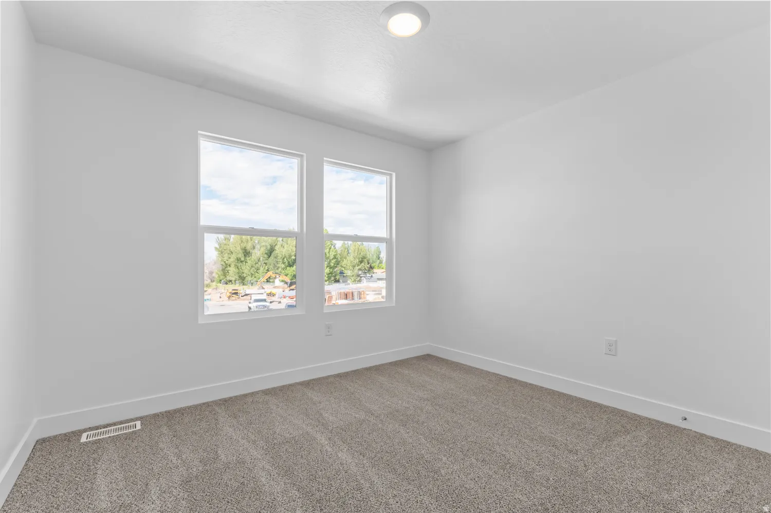 Neutral wall paint, plush carpeting, recessed ceiling lighting, and dual windows