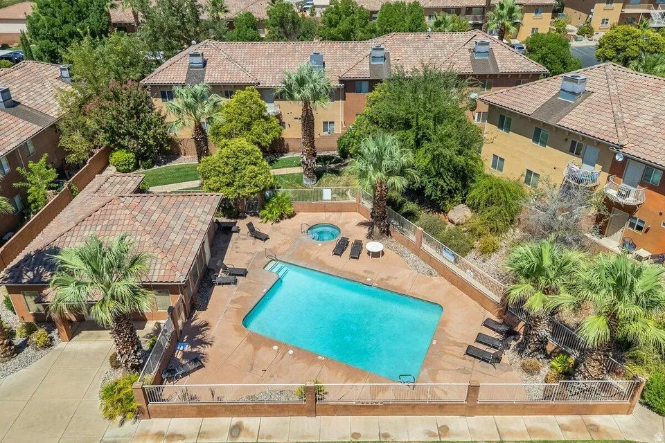 Gated swimming pool area featuring a rectangular pool, integrated spa, and surrounding hardscaping