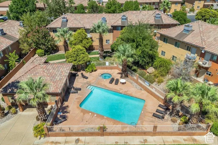 Gated swimming pool area featuring a rectangular pool, integrated spa, and surrounding hardscaping