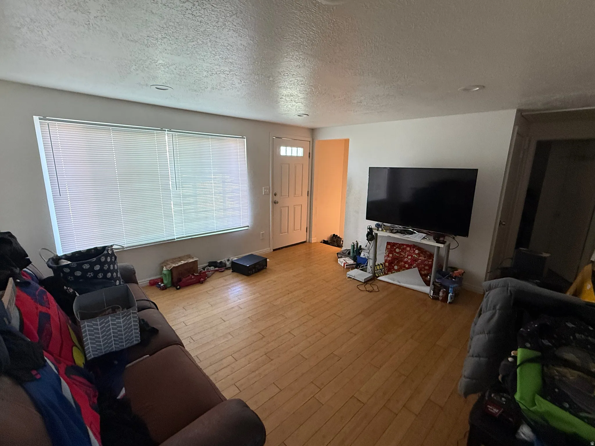 Living room with a textured ceiling and wood finished floors
