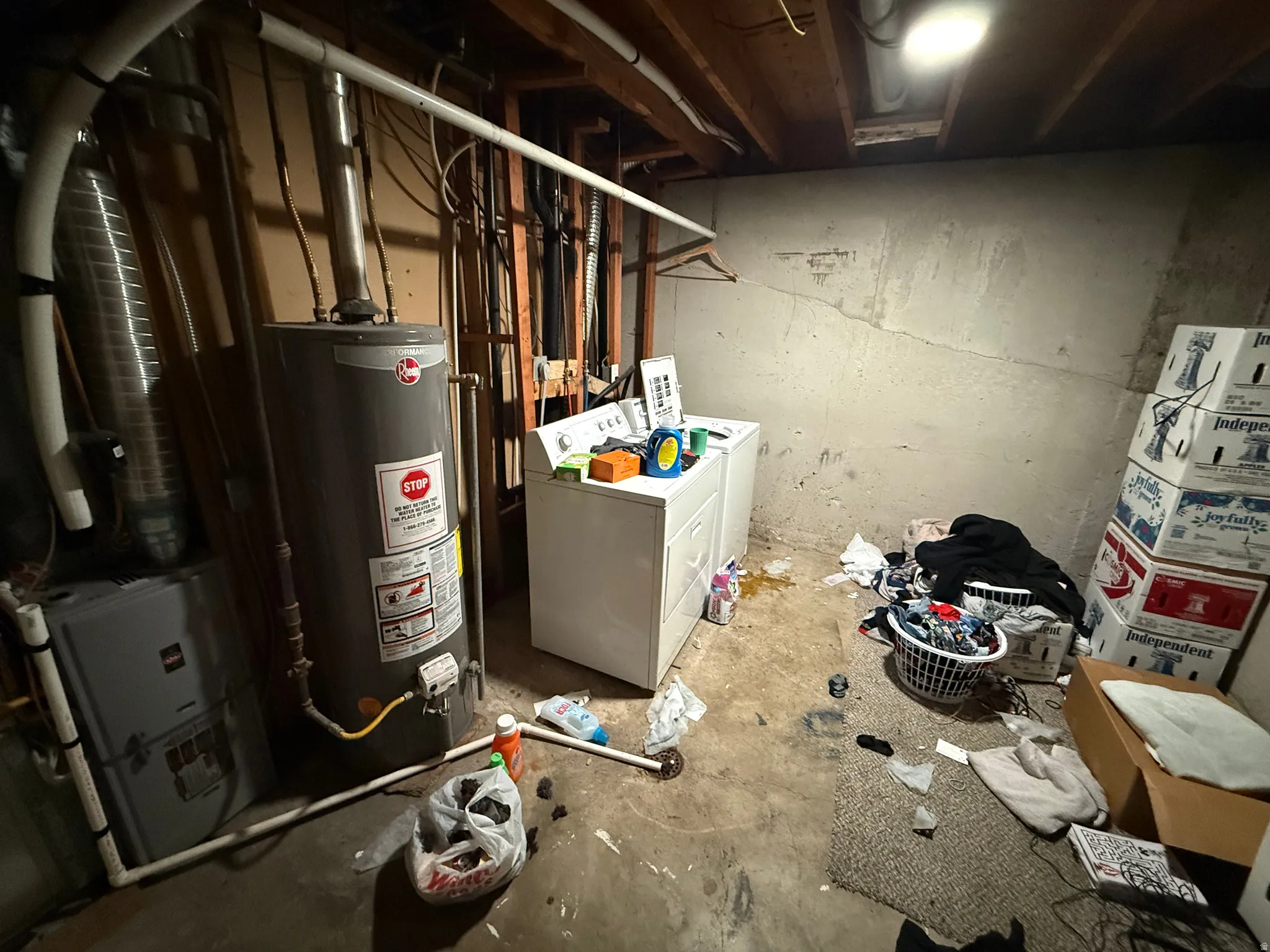 Unfinished basement with water heater, washer and dryer, and heating unit