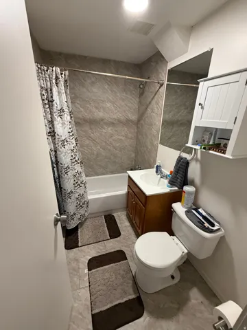 Bathroom with vanity and shower / bath combination with curtain