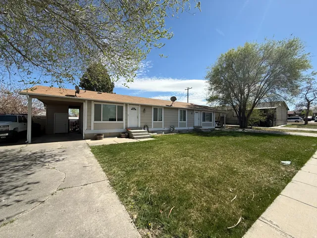 Single story home featuring a front yard, a carport, and driveway