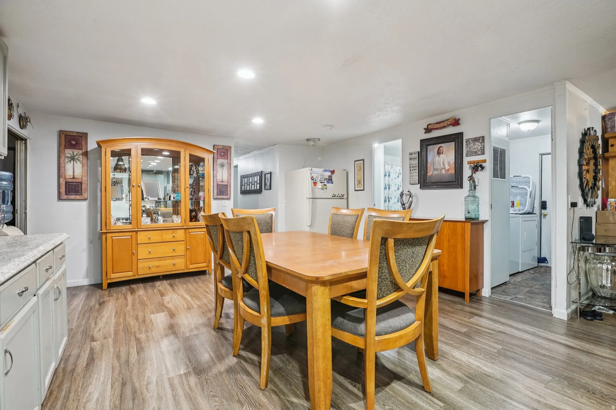 Dining room with light wood-style floors and recessed lighting