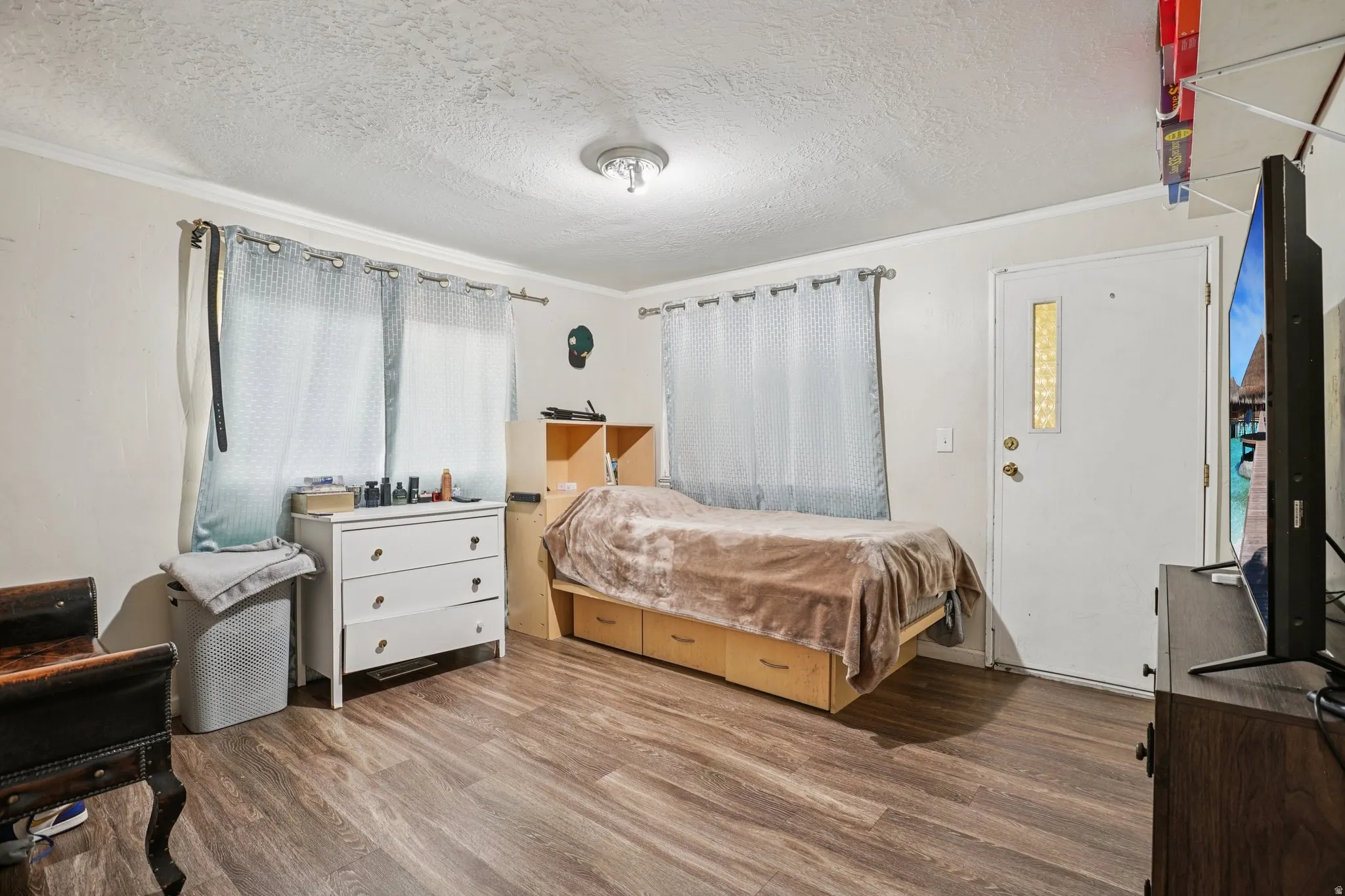 Bedroom with wood finished floors and a textured ceiling