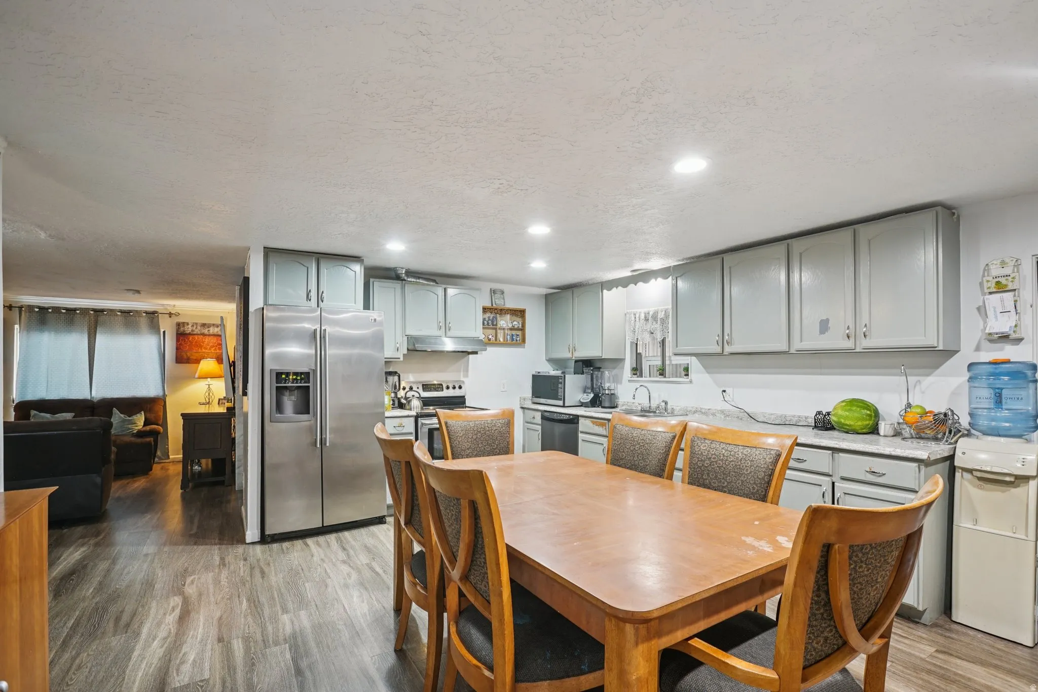 Dining room featuring light wood-style floors, a textured ceiling, and recessed lighting