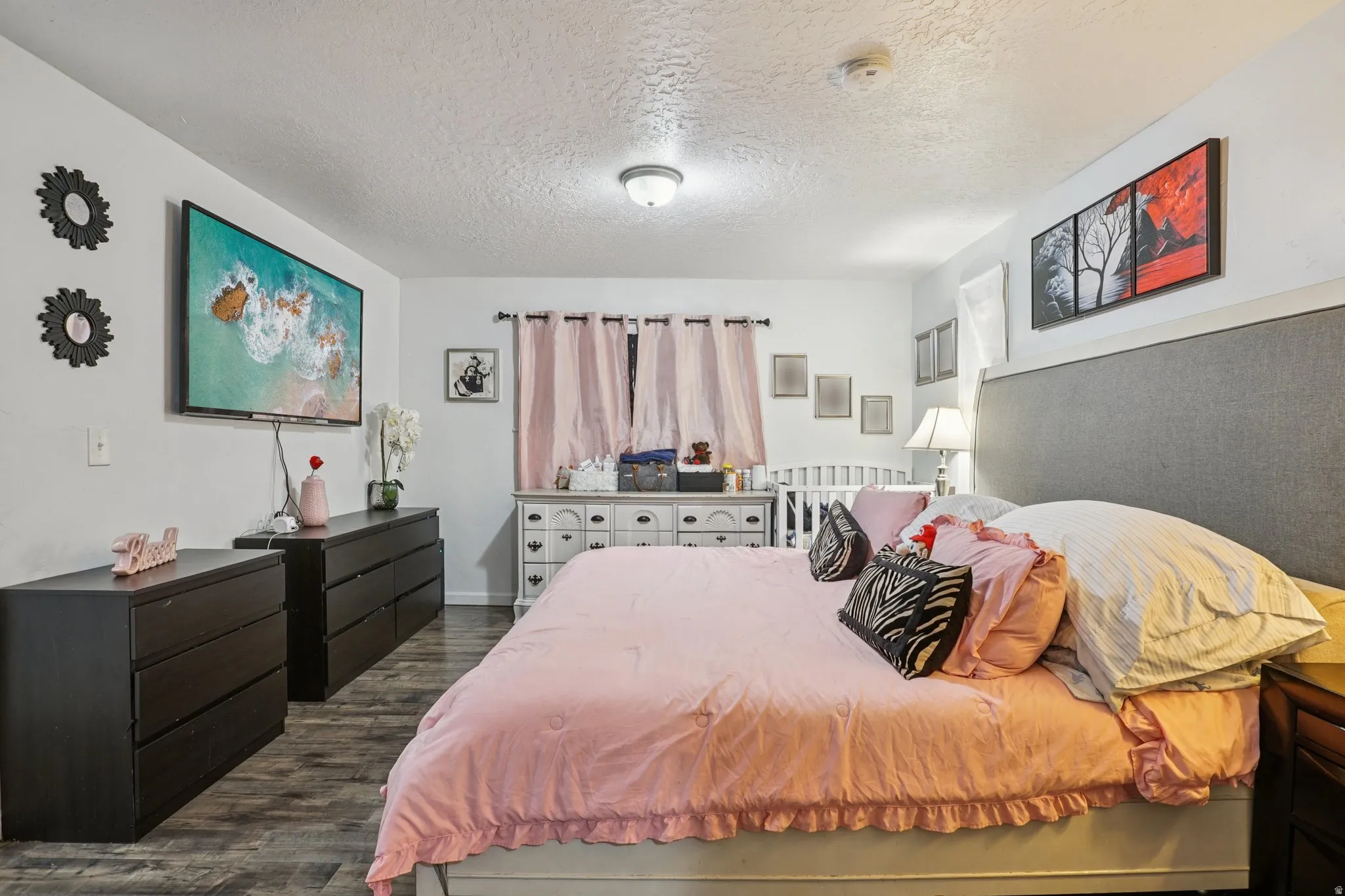 Bedroom with a textured ceiling and dark wood-style flooring