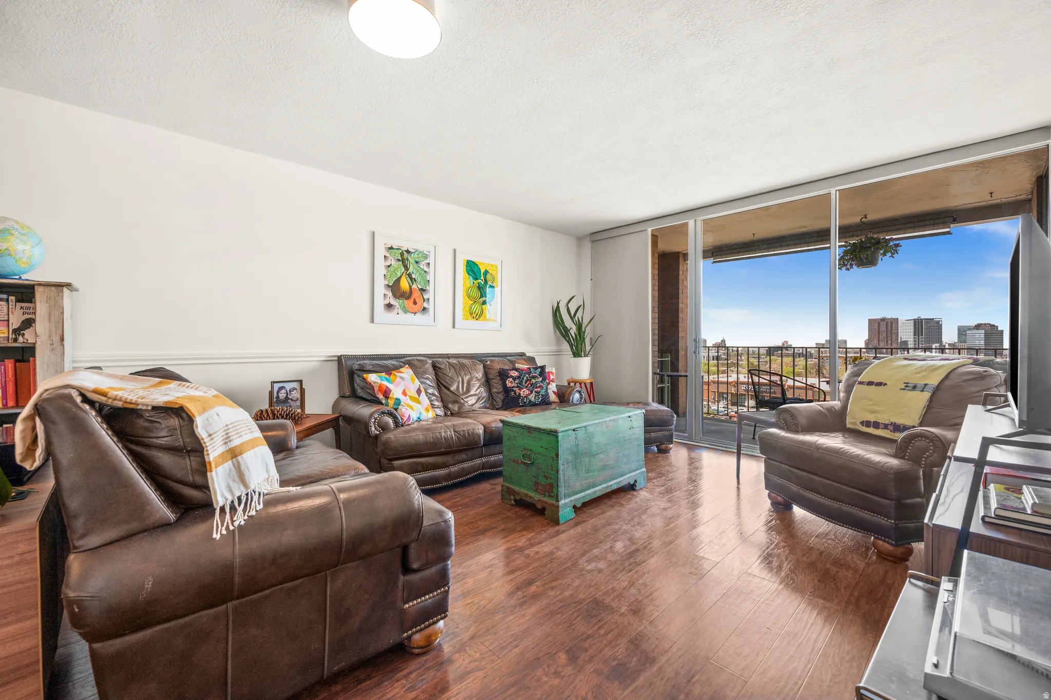 Living area featuring expansive windows, wood finished floors, and a textured ceiling