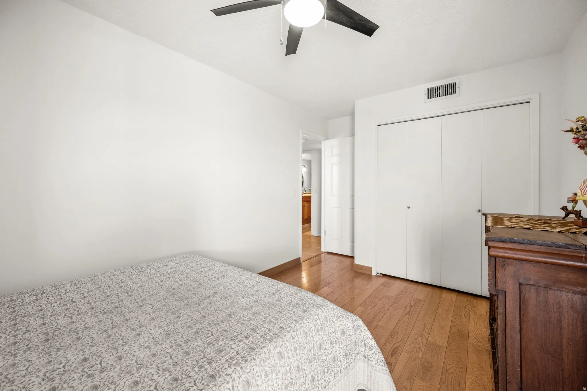 Bedroom with light wood finished floors, a closet, and ceiling fan