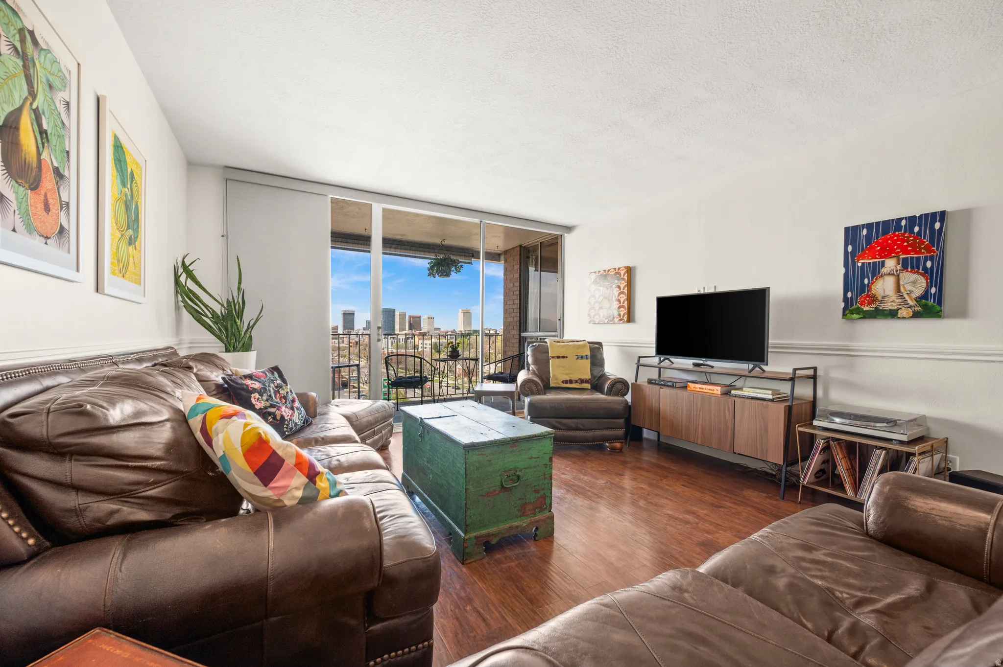 Living room with floor to ceiling windows, dark wood-type flooring, and a textured ceiling