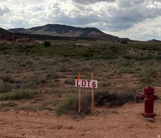 Expansive lot featuring a red fire hydrant, a lot marker, and a distant mountain backdrop