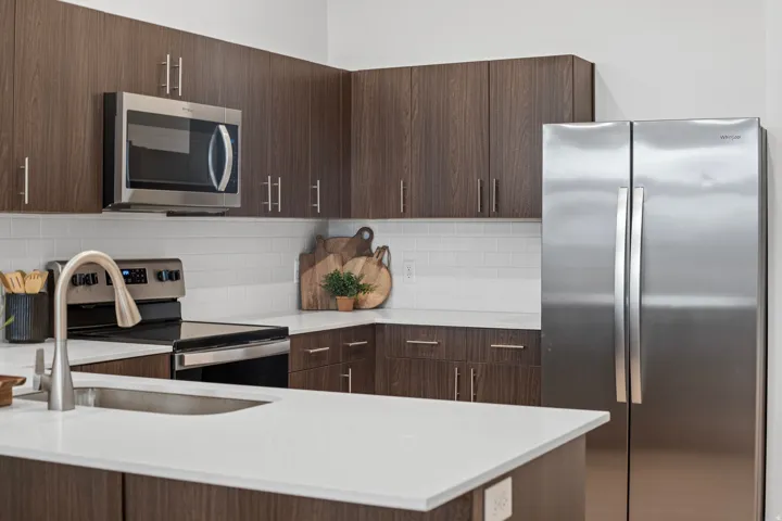 Kitchen with dark wood tone finishes and stainless steel appliances. *fridge not included*