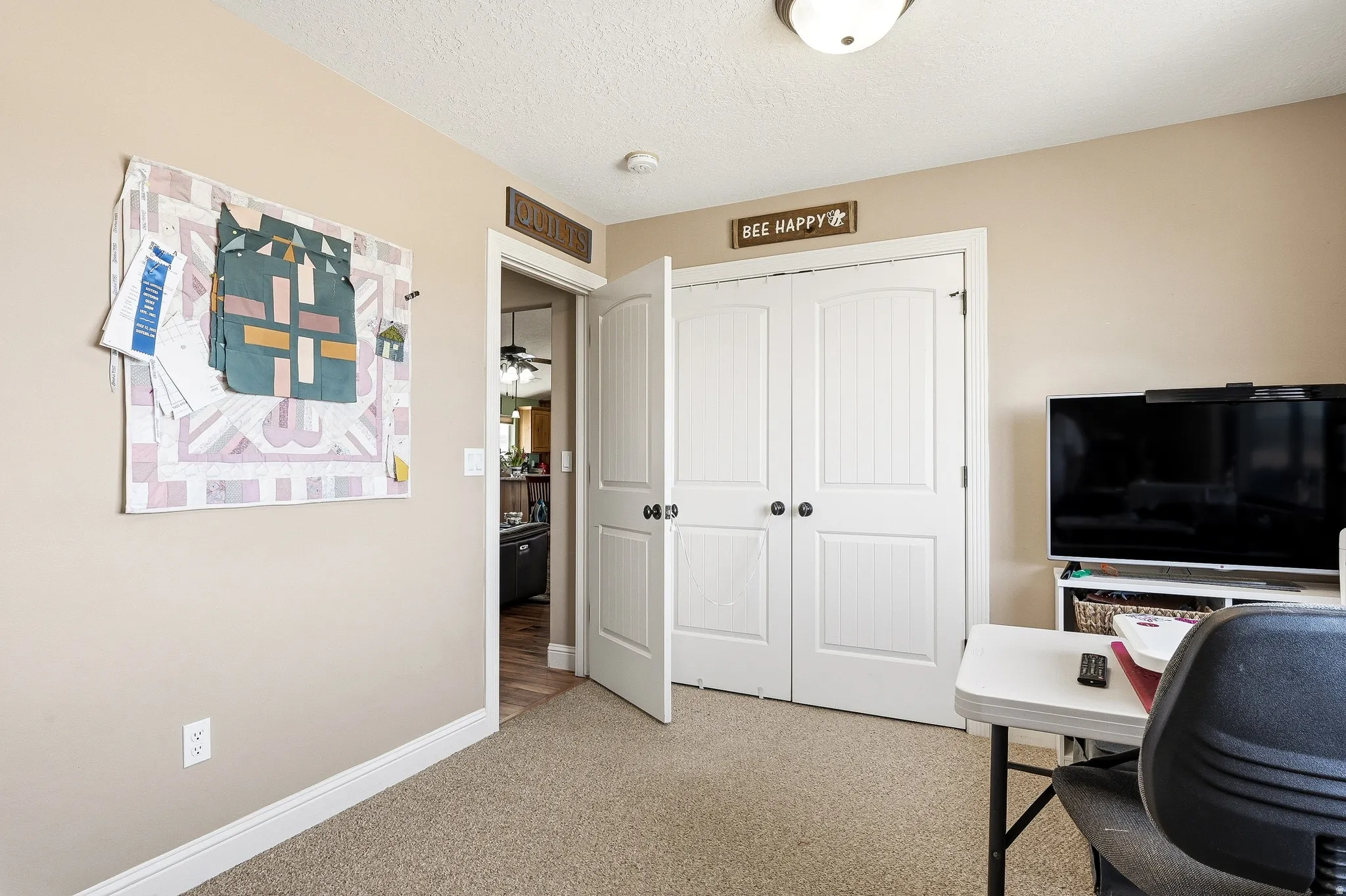 Office area featuring light carpet and a textured ceiling